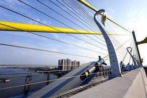 Yellow Cables On A Suspension Bridge Against Blue Sky In Bangkok photo