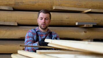 bouwer vouwen houten planken. concept - uitverkoop van timmerhout. bouwer is overwegen hout planken. concept - hout verwerken bedrijf. hout hout stack van houten planken video