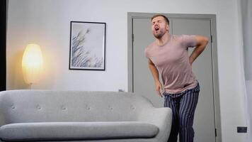 Young man suffering from backpain while lifting sofa in living room video