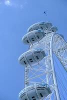 Londres ojo o el milenio rueda y un helicóptero sobrevolando él. foto