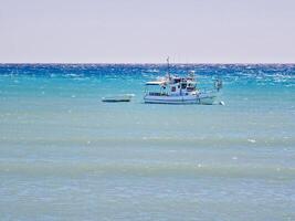 Fishing boats set against rough sea off the bay of Avdimou, Cyprus photo