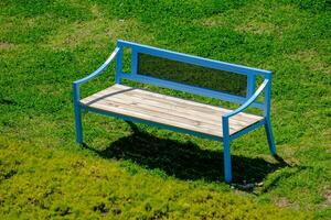 Blue bench on grass at a park. Suitable as a background photo