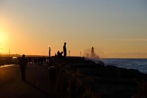 Silhouettes of people strolling at the Kyrenia Harbour at the blue hour in Cyprus photo