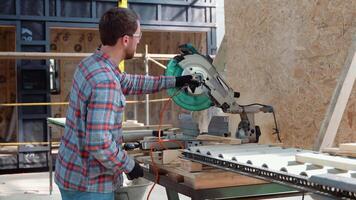 gebouw aannemer arbeider gebruik makend van hand- gehouden worm rit circulaire zag naar besnoeiing borden Aan een nieuw huis constructie project video