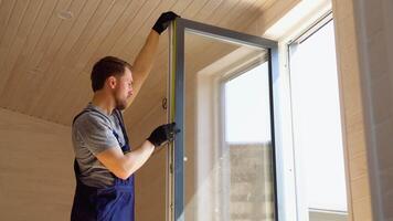 constructor trabajador en uniforme instalando cloruro de polivinilo ventana con medida cinta en de madera modular móvil hogar video