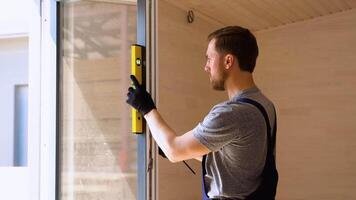 trabalhador medidas do a vertical desvio do PVC janelas dentro de madeira modular casa video