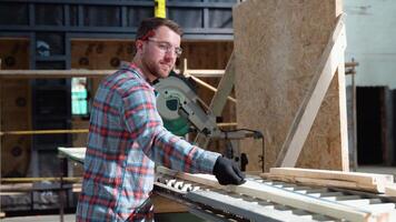 Building contractor worker using hand held worm drive circular saw to cut boards on a new home constructiion project video