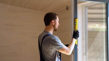 Worker measures of the vertical deviation of pvc windows in wooden prefabricated house video