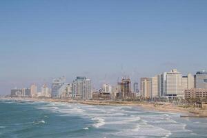 Panoramic View of Tel-Aviv Coastline with City Skyline and Waves Crashing on the Beach photo