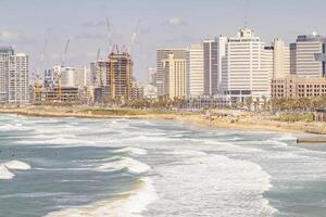 Panoramic View of Tel-Aviv Coastline with City Skyline and Waves Crashing on the Beach photo