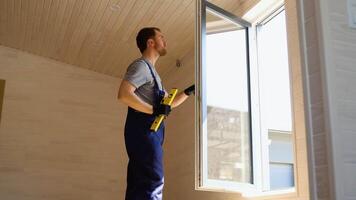 trabajador medidas de el vertical desviación de cloruro de polivinilo ventanas en nuevo de madera hotel habitación video