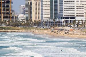 Panoramic View of Tel-Aviv Coastline with City Skyline and Waves Crashing on the Beach photo