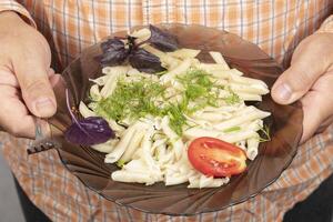 en un plato de pasta, tomate albahaca y eneldo. foto