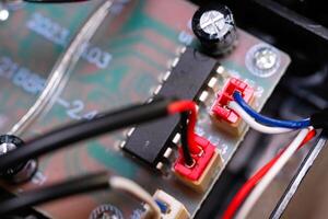 Macrophotography. Electrical closeup. Close up shot of the electrical circuit in an RC Remote Control Car. Background texture of PCB boards, cables, sockets and electronic devices. Shot with a macro photo