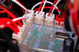 Macrophotography. Electrical closeup. Close up shot of the electrical circuit in an RC Remote Control Car. Background texture of PCB boards, cables, sockets and electronic devices. Shot with a macro photo