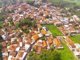 Aerial View of Nagreg City - Indonesia from the Sky. There are rice fields, valleys and hills, squeezed by dense settlements and a main road. Shot from a drone flying 200 meters high. photo