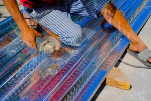 Industrial Photography. Construction works. Photo of a worker's hands cutting a metal deck. Cutting metal deck using a grinder. Bandung - Indonesia, Asia