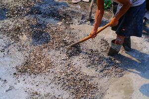 industrial fotografía. construcción trabajo actividades. trabajadores son cavar y mezcla cemento con arena y piedras para cemento piezas fundidas. Bandung - Indonesia, Asia foto