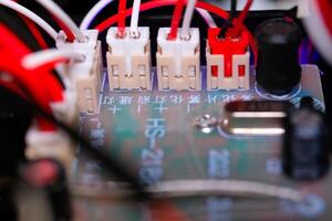 Macrophotography. Electrical closeup. Close up shot of the electrical circuit in an RC Remote Control Car. Background texture of PCB boards, cables, sockets and electronic devices. Shot with a macro photo