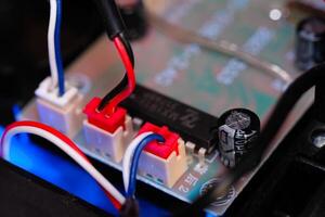 Macrophotography. Electrical closeup. Close up shot of the electrical circuit in an RC Remote Control Car. Background texture of PCB boards, cables, sockets and electronic devices. Shot with a macro photo