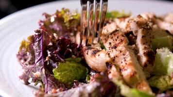 Closeup pan of caesar salad with cherry kumato tomatoes on wooden table video