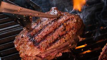 cuisine steaks sur le Feu dans réel fermer vue de juteux cuit tranches de Viande avec flammes. original plat recette. professionnel cuisson, nourriture recette, cuisson. horizontal . Haut voir. video