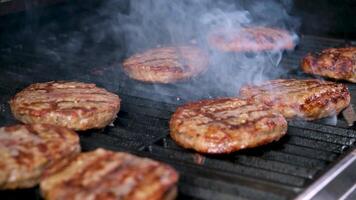 Food festival, the process of cooking burger on grill, meat and bun are fried on grill, burger ingredients. juicy burger patties fried over open fire pierce with spatula meat beef flows juicy video