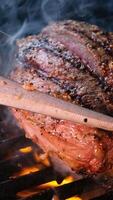 Grilled meat steak on stainless grill depot with flames on dark background. Food and cuisine concept. video