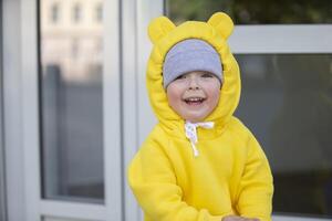 gracioso pequeño niña en un calentar amarillo traje con orejas en un caminar. foto