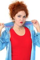 Portrait of a beautiful red-haired girl with bright makeup in a red T-shirt and denim shirt on a white background. Fire Girl. photo