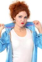 Portrait of a beautiful cheerful red-haired girl in a denim shirt and white T-shirt. photo