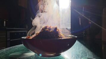 piatto con caldo vapore sorge su verdure porridge carote fritte con cipolle avvicinamento un' lotto di vapore Fumo bicchiere graffiato tavolo ordinario cucina contro il sfondo di finestra sole raggi casa cucinando video