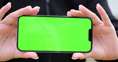 Slide shot of female teen girl using smartphone with green screen sitting at the table, 4k 60fps prores footage video