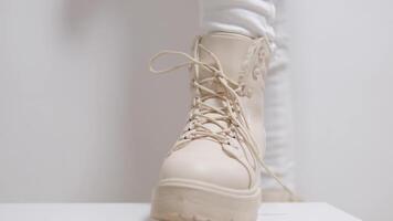 lumière des chaussures aux femmes bottes avec lacets avec haute semelles sur une blanc Contexte classique mode spectacle pour achat pour hiver l'automne des chaussures boutique beige Couleur laiteux Couleur video