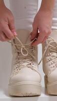 close-up. a little girl puts on her lace-up winter boots. the concept of children's independence and the ability to tie shoelaces. video