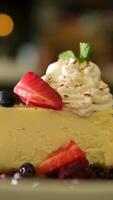 Strawberry cheesecake served on plate on dim wooden table foundation. video