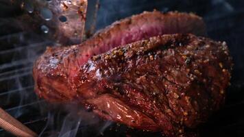 cortar a carne sobre Mal passado fogo carne médio bife cozinhando em grade lento movimento video