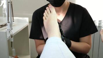 profissional pé massagem dentro pedicure salão pé Cuidado mulher médico dentro Preto luvas fazendo massagem com circular amassar movimentos pé tratamento problemas recuperação conjunto do diferente exercícios para dedos do pé video