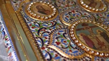 A closeup shot of a decorative red Bible with a gold cross in a church video