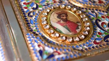 A closeup shot of a decorative red Bible with a gold cross in a church video