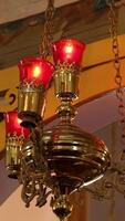 closeup of beautiful decorative red candle hanging on chains in the church video