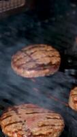 cucinando hamburger su un' caldo griglia con un' fiamma Manzo cotolette cucinato su un' barbecue cottura alla griglia Manzo e Maiale polpetta per festa. video