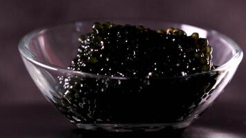 schwarz Kaviar im ein Weiß Teller , Oliven und Zitrone auf ein schwarz Hintergrund video