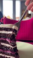 Vertikale ist dominiert durch lila Farbe köstlich Beere Kuchen Schnitt mit ein Gabel Johannisbeere Dessert Schokolade Kuchen Weiß sauer Sahne Butter Sahne video