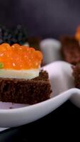 partitionerad maträtt med svart och röd kaviar på trä- bakgrund video