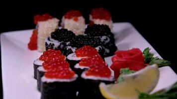 Sushi avec rouge noir caviar servi sur une assiette tourbillonne dans de face de le caméra fermer une lot de argent richesse luxe vacances la vie sans pour autant règles dans une milliardaire millionnaire nourriture pour riches une lot de argent video