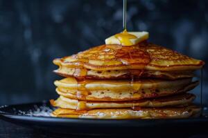 Stack of fluffy pancakes With butter and maple syrup photo