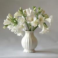 A porcelain vase holds a bouquet of fragrant freesia flowers. photo