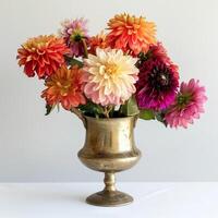 Vintage style brass vase holding a bunch of colorful dahlias. photo