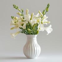 A porcelain vase holds a bouquet of fragrant freesia flowers. photo